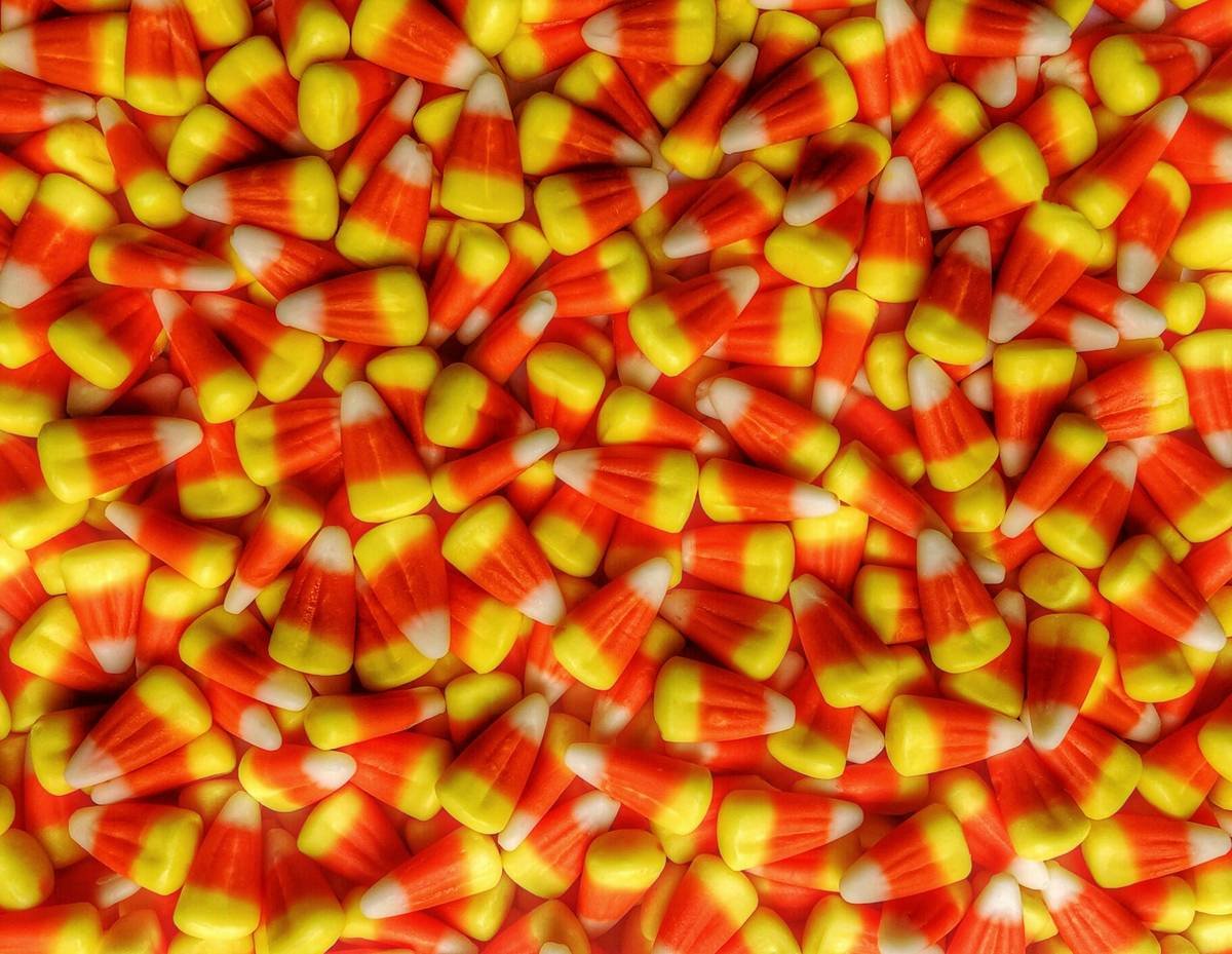 Digital candy thermometer clipped to saucepan showing 298°F during candy corn cooking