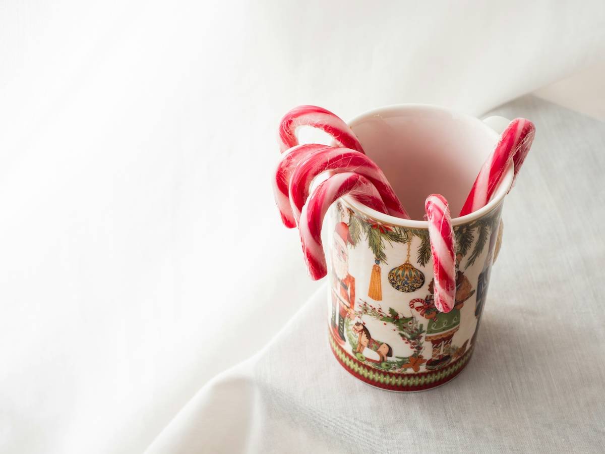 Side-by-side photo showing three melted candy cane spoons versus two intact stainless steel ones after exposure to 290°F syrup